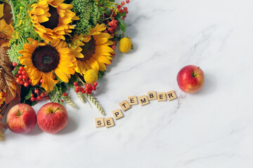 Autumn flowers bouquet and apples on marble background. September time. seasonal composition. top view