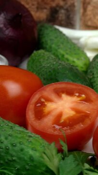 Delicious fresh vegetables for simple summer healthy vegetarian salad. Cabbage, tomatoes, onions, garlic, parsley and dill. Healthy ingredients for healthy food. Vertical video.