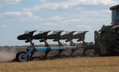 Agricultural tractor plowing a field before sowing