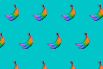 Pattern of rainbow colored bananas on pastel blue background