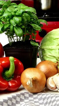 Variety of fresh, raw vegetables lie in heap on kitchen table. Ingredients for vegetable salad or other vegetable dishes. Healthy vegetarian or vegan food concept. Vertical video.