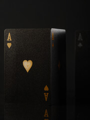 Obraz premium Casino. Gambling. Poker cards. Ace of hearts. Black background. Minimalism. Risk, chance of luck. Poker club, strategy games, gambling and advertising business.