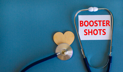 Covid-19 booster shots vaccine symbol. White card with words booster shots, beautiful blue background, wooden heart and stethoscope. Covid-19 booster shots vaccine concept. - obrazy, fototapety, plakaty