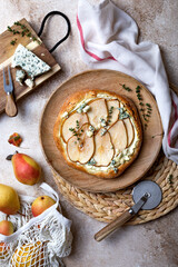 Pizza with pear, thyme, ricotta and blue cheese on  wooden board