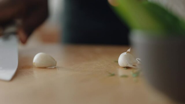 close up hands cutting garlic cloves using knife preparing fresh homemade meal chopping vegetables for cooking healthy organic lifestyle at home 4k footage
