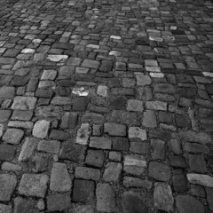 Retro cobblestone pavement. Stone  paved backdrop gray-scale