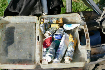 artist paint box filled with used tubes of oil paint colors