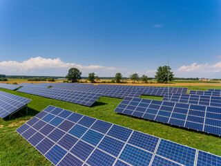 Photovoltaic farm - renewable energy from sunlight - photovoltaic panels set on a green field. Renewable energy supplying medium-sized enterprises