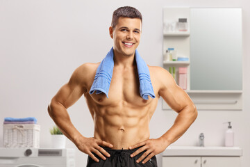 Handsome young shirtless man standing in a bathroom