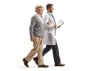Full length profile shot of a male doctor walking and holding an elderly patient under his shoulder