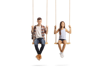 Little girl and a male teenager sitting on wooden swings