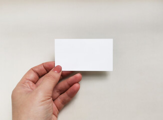 Female hand holding a card. Isolated on white background.