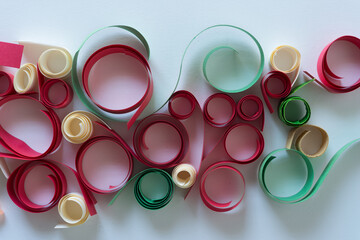 paper coils in red, green, and ivory on a light background