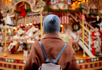 blonde woman near carousel at the Christmas market