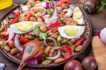 Turkish appetizer Piyaz on a wooden table with a spoon. Close-up