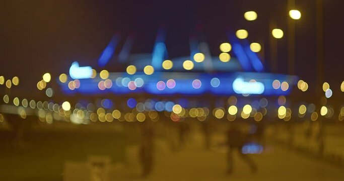 Urban landscape in the style of bokeh video background. park by the light of lanterns at night in disfocus. futage bokeh night. stadium in St. Petersburg at night in disfocus.