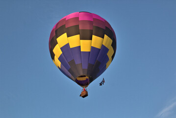 Balloon pilot flying his colorful balloon against the blue skies overhead