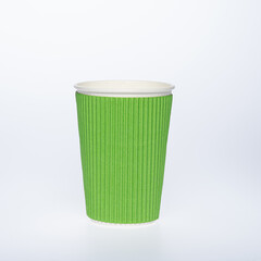 Photo of a disposable green paper cup on a white background. Photo of a colored coffee cup made of recyclable materials. Empty paper coffee cup.