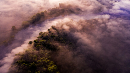 Aerial  view of a beautiful summer  landscape with a fog while dawn.  Photo from drone of a foggy landscape in spring. Top view to land while sunrise. Early morning in nature, misty  weather.