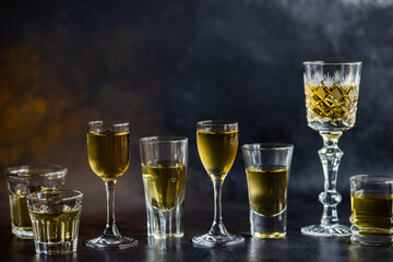 Row of assorted shot glasses, wine glasses and tumblers filled with traditional Georgian chacha brandy