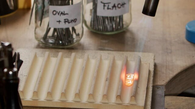 A closeup shot of gold small pieces melting in the casting tool