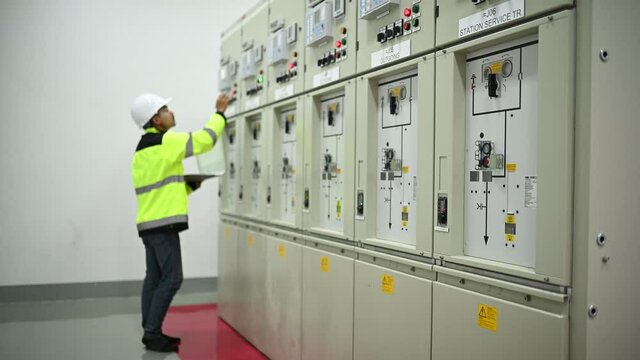 Electrical engineer man checking voltage at the Power Distribution Cabinet in the control room,preventive maintenance Yearly,Thailand Electrician working at company