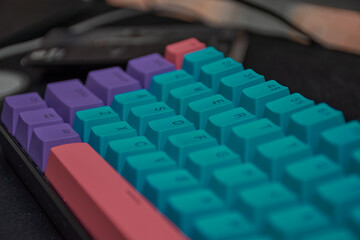 Fototapeta na wymiar Light pink navy blue and light purple pastel keyboard in gamer room shining