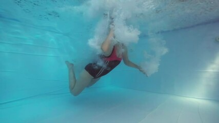 Woman falls into the pool, underwater view of the falling woman