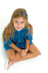 Charming little girl sitting on floor in studio