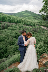 a gentle beautiful hugging newlyweds in a wedding ceremony in the mountains