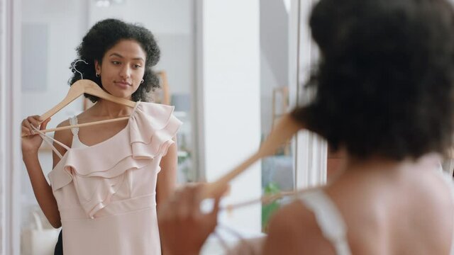attractive young woman getting dressed looking in mirror choosing outfit putting on clothes enjoying fashion choice positive self image feeling confident at home 4k footage