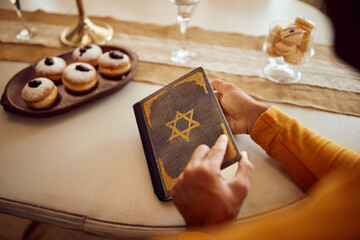 Close-up of Jewish man reading Tanakh on Hanukkah at home.