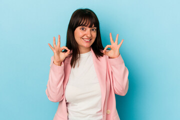 Young curvy caucasian woman isolated on blue background cheerful and confident showing ok gesture.