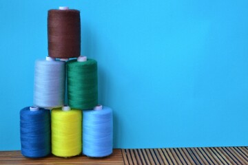 Tower of colored threads on a light blue background