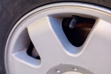 Nipple cap on the wheel. Place the air replenishment tires. Toned background with selective focus...