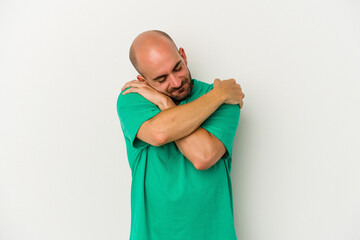 Young bald man isolated on white background hugs, smiling carefree and happy.