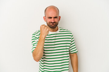 Young bald man isolated on white background showing fist to camera, aggressive facial expression.