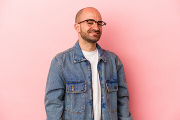 Fototapeta premium Young caucasian bald man isolated on pink background confident keeping hands on hips.