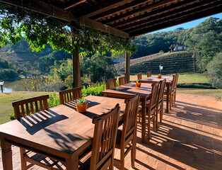 Terrace with wooden tables and chairs in a pleasant place in the open sky.