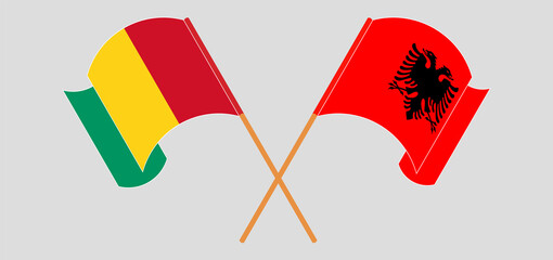 Crossed and waving flags of Guinea and Albania
