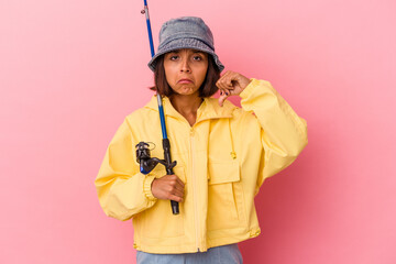 Young mixed race woman practicing fishing isolated on pink background showing a dislike gesture, thumbs down. Disagreement concept.