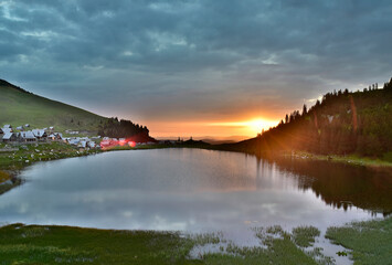 Majestic landscape with sunrise reflects on the lake on the top of mountain with amazing nature around.