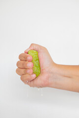 Hand squeeze lime with lime drop on a white background