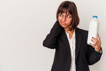 Young mixed race business woman holding a milk bottle isolated on white background touching back of...