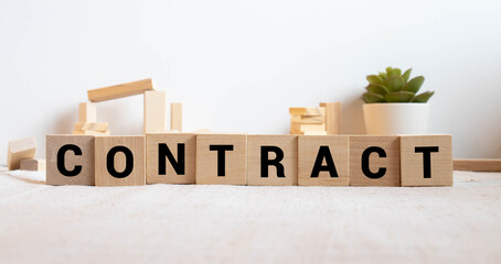 On a light background on wooden cubes the word CONTRACT is written. Business concept.