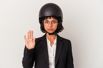 Young mixed race business woman wearing a motorbike helmet isolated standing with outstretched hand showing stop sign, preventing you.