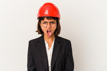Young architect woman with red helmet isolated on white background screaming very angry and aggressive.