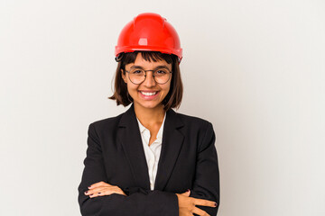 Young architect woman with red helmet isolated on white background laughing and having fun.