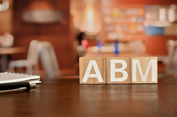 Naklejka na ściany i meble On a wood board, wooden word cubes are arranged in the letters ABM. It is an abbreviation for Account Based Marketing.