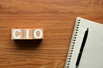 On a wood board, wooden word cubes are arranged in the letters CIO. It is an abbreviation for chief information officer.